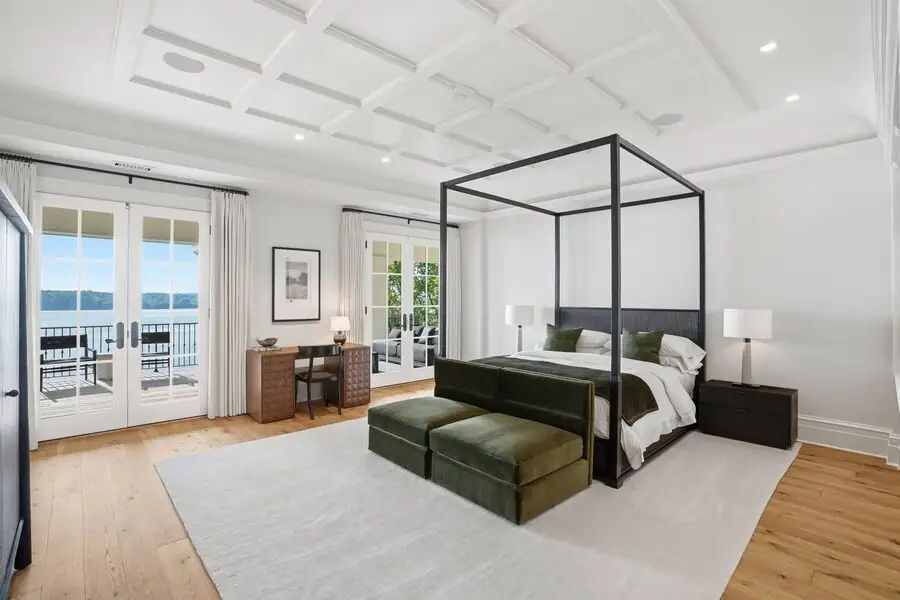 Primary bedroom — canopy bed, river through doors